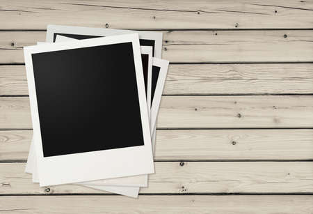 Polaroid photo frames on wooden background