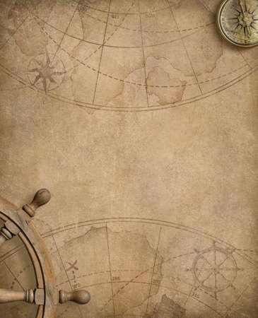 aged compass and steering wheel over nautical mapの写真素材