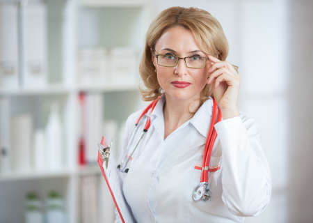 Serious pharmaceutist woman in glasses looking at cameraの写真素材