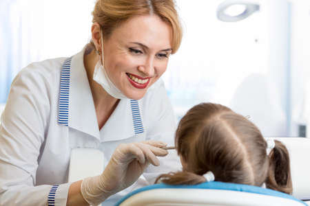 attractive dentist woman examining kid girlの写真素材