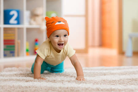 baby boy at home crawling on carpetの写真素材
