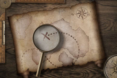 Pirates' old treasure map on wooden desk with compass and ruler 3d illustrationの写真素材
