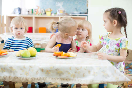 Funny kid kissing another kid in kindergartenの写真素材