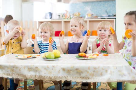 Funny kids eating fruits in day care centreの写真素材
