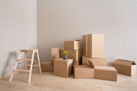 Cardboard boxes pile in new empty room with step-ladderの写真素材