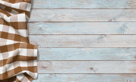 brown picnic tablecloth on left side of blue wooden tableの写真素材