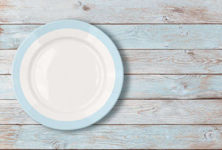 empty dinner plate on on blue wooden tableの写真素材