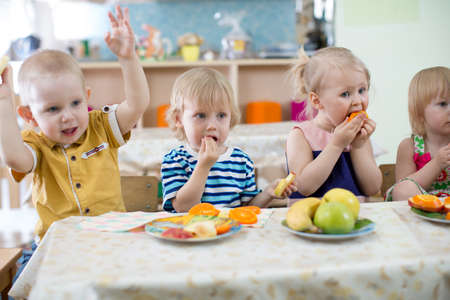 little kids eating in kindergartenの写真素材