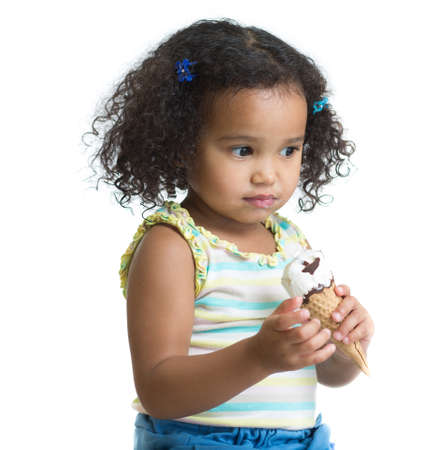 Serious kid eating ice cream isolatedの写真素材