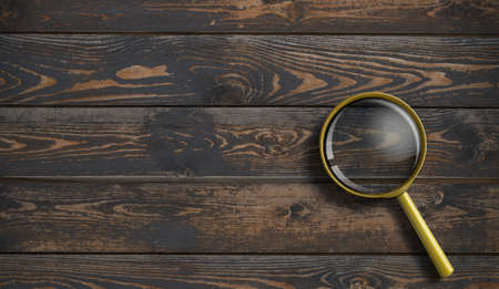 Magnifying glass on wooden table surface top viewの写真素材