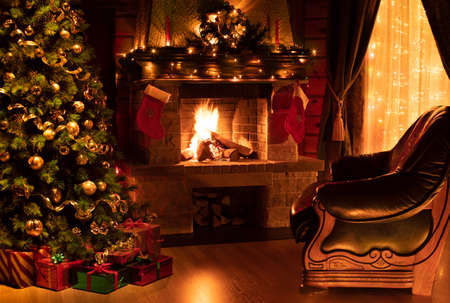 Christmas decorated interior with fireplace, armchair, window and treeの写真素材