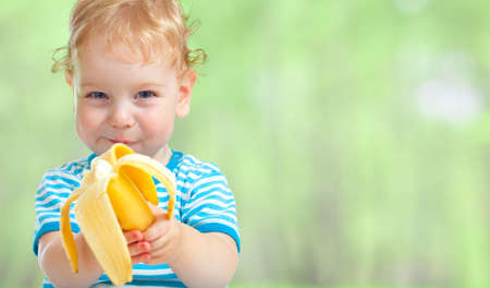 happy kid eating banana fruitの写真素材