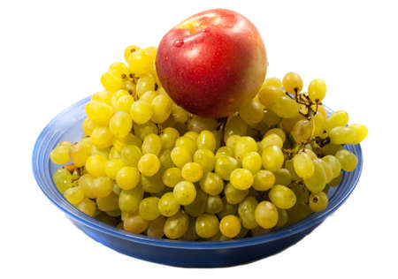the bunch of grapes and an Apple lying on the plateの写真素材