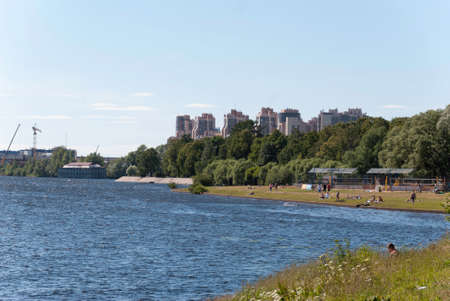 city beach pond sunny summer day and people are resting on itの写真素材