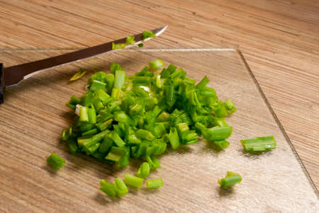 chopped green onions on a kitchen cutting Board