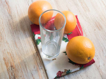 glass of orange juice and oranges on a napkinの写真素材