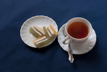 hibiscus tea and a plate of colored marmalade on a blue fabric backgroundの写真素材