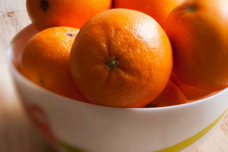 oranges on a yellow dish. Wooden backgroundの写真素材
