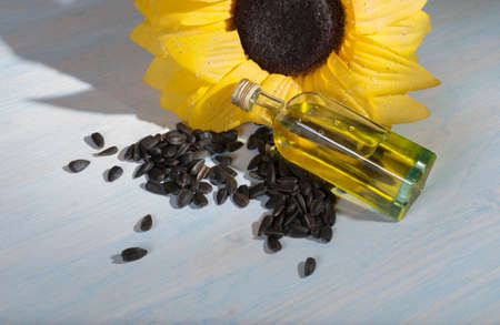 bottle of oil and sunflower seeds on wooden backgroundの写真素材