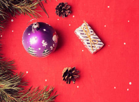 Christmas balls, branches and cones on a red background.の写真素材