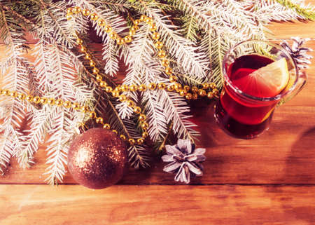 Mug with mulled wine, fir branches on wooden background.の写真素材