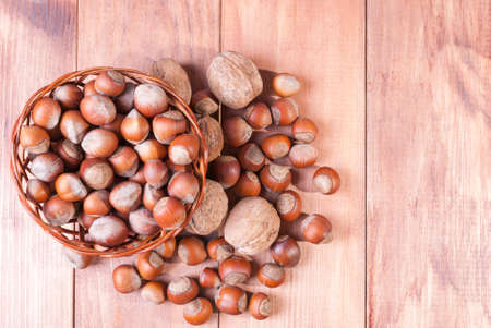 Hazelnuts in a basket on a wooden table. The view from the top.の写真素材