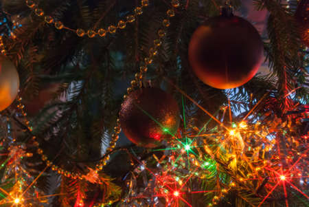Christmas tree branch with Christmas balls on the background blurred, and tinsel garlandsの写真素材