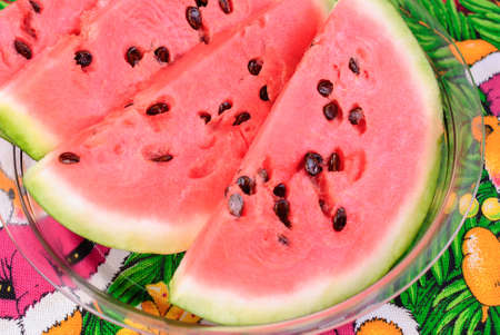 Chunks of watermelon with big seeds lying on a plateの写真素材