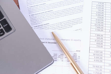 The notebook and pen lying on business papersの写真素材