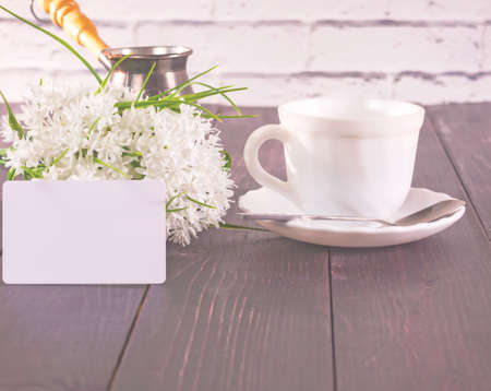 Cup of coffee on wooden table with flower background.の写真素材