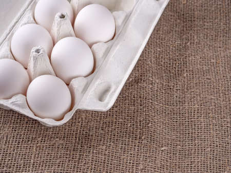White eggs in a package on a fabric background