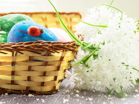 Easter eggs and white flowers on light background.の写真素材