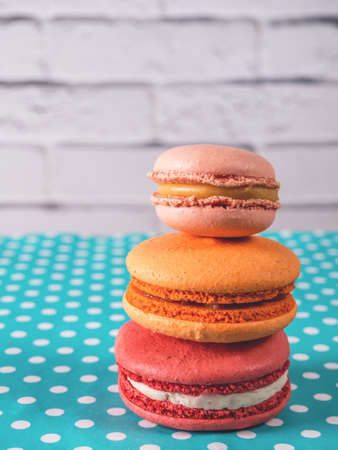 Stack of three multicolored French macarons on a tableの写真素材