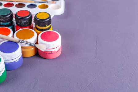 Desk of an artist with watercolor paints and paintbrushesの写真素材