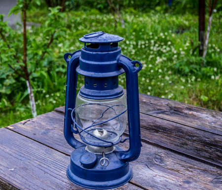 Old oil lamp on a gray worn wooden table
