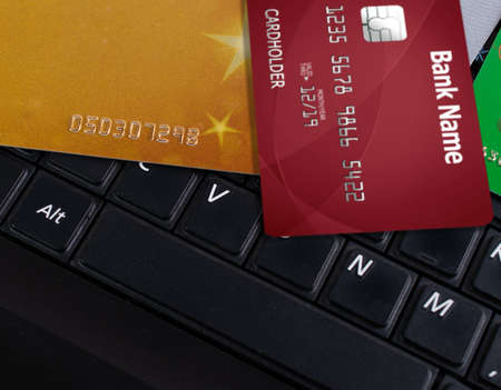 Black laptop keyboard and bank credit cards. Close-up