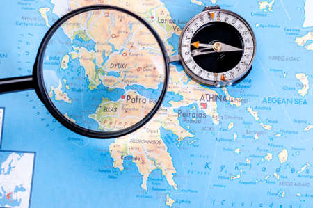 Map of Greece with a compass and magnifying glass