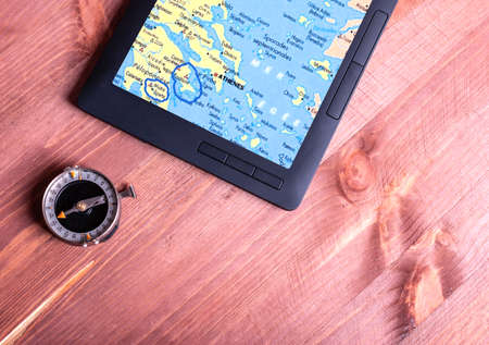 Old compass, tablet with a map of Greece on the screen on the tableの写真素材