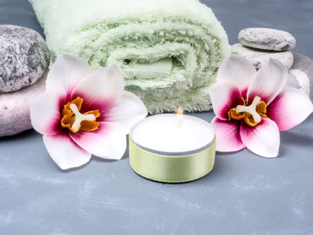 Spa composition with stones, flowers and a burning candle