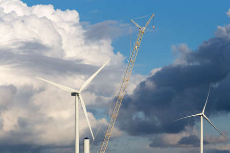 wind turbines and a crane with a dramatic sky backgroundの写真素材