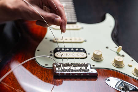 Replacing strings on an electric guitarの写真素材