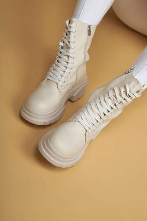 Perfect female legs.  Beautiful female legs in summer shoes in white designer pants on a yellow background.の写真素材