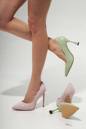 Fashion model girl legs portrait on white background. Beauty stylish woman posing in fashion clothes in studio. Summer fashion, trendy shoes, casual style. Woman chooses shoes collection autumn spring 2022. Long slim beautiful female feet.の写真素材