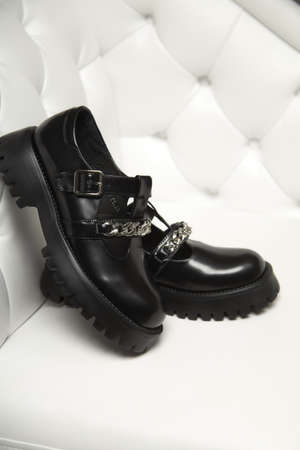 Black street sneakers on the women's legs. Comfortable and beautiful black shoes on white background.の写真素材