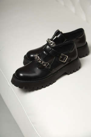 Black street sneakers on the women's legs. Comfortable and beautiful black shoes on white background.の写真素材