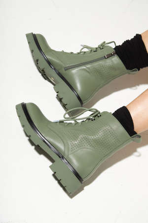 New fashion collection of footwear autumn winter on the feet of models. Boots in the style of a military on a white background. Fashion photos of shoes. Winter bootの写真素材