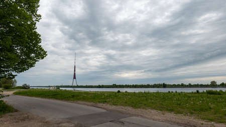 Riga Radio and TV Tower near Daugava river with green trees.の写真素材
