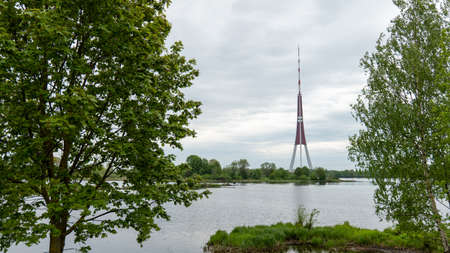 Riga Radio and TV Tower near Daugava river with green trees.の写真素材