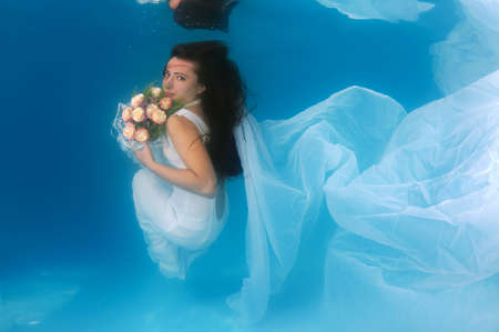 Bride in underwater for wedding in a poolの写真素材