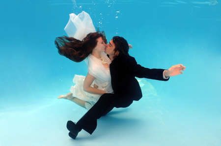 Bride and groom kissing, underwater wedding in a poolの写真素材